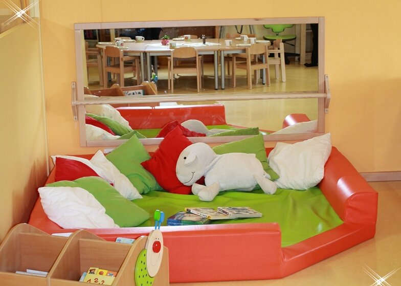 Kuschelecke mit Kuscheltieren und vielen Kissen.